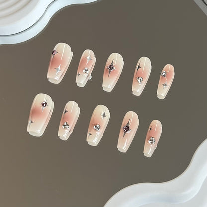 1. Blushcolored medium coffin presson nails with a delicate starry pattern, perfect for a chic and radiant look.