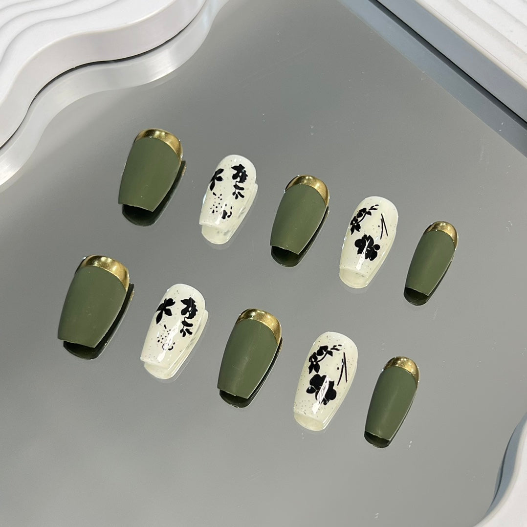 3. Seasonal green presson nails with goldoutlined fall leaves for a festive touch.