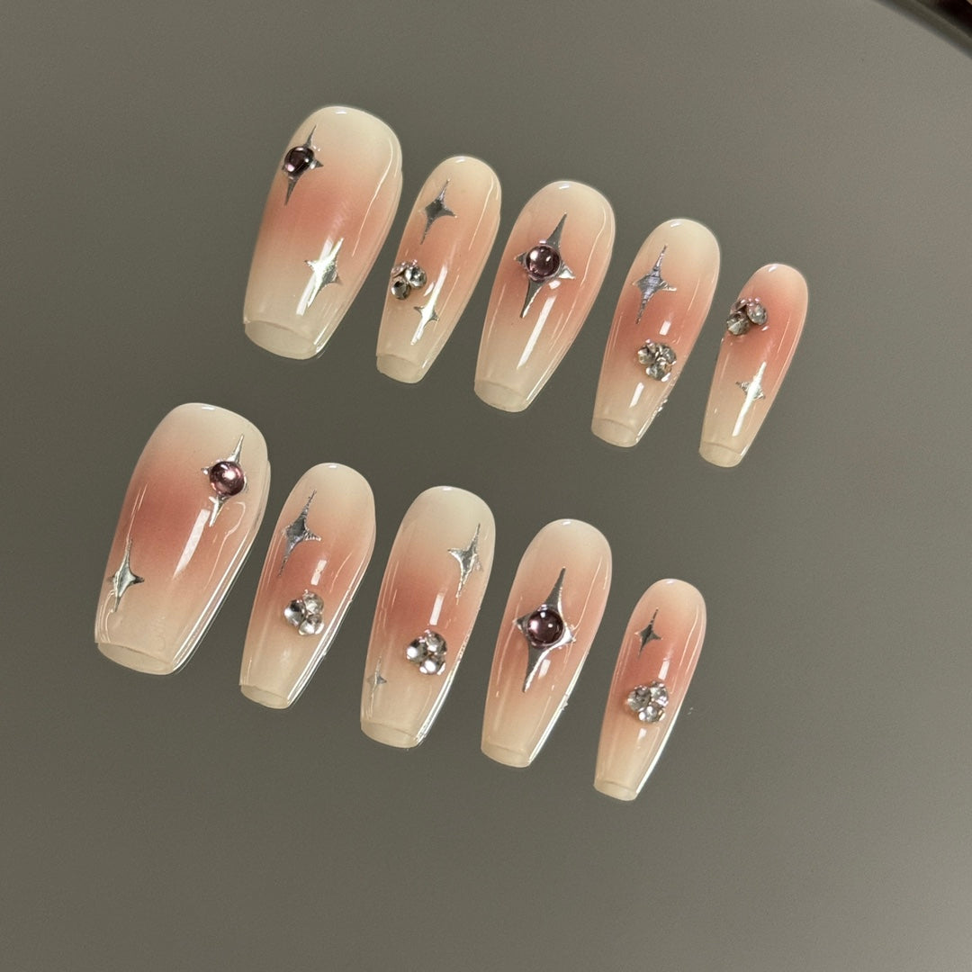 3. Cute and classy presson nail set with blush medium coffin nails, embellished with a subtle star pattern for a touch of elegance.