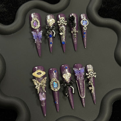 1. Elegant dark purple presson nails with intricate black butterfly accents for a hauntingly beautiful Halloween look.