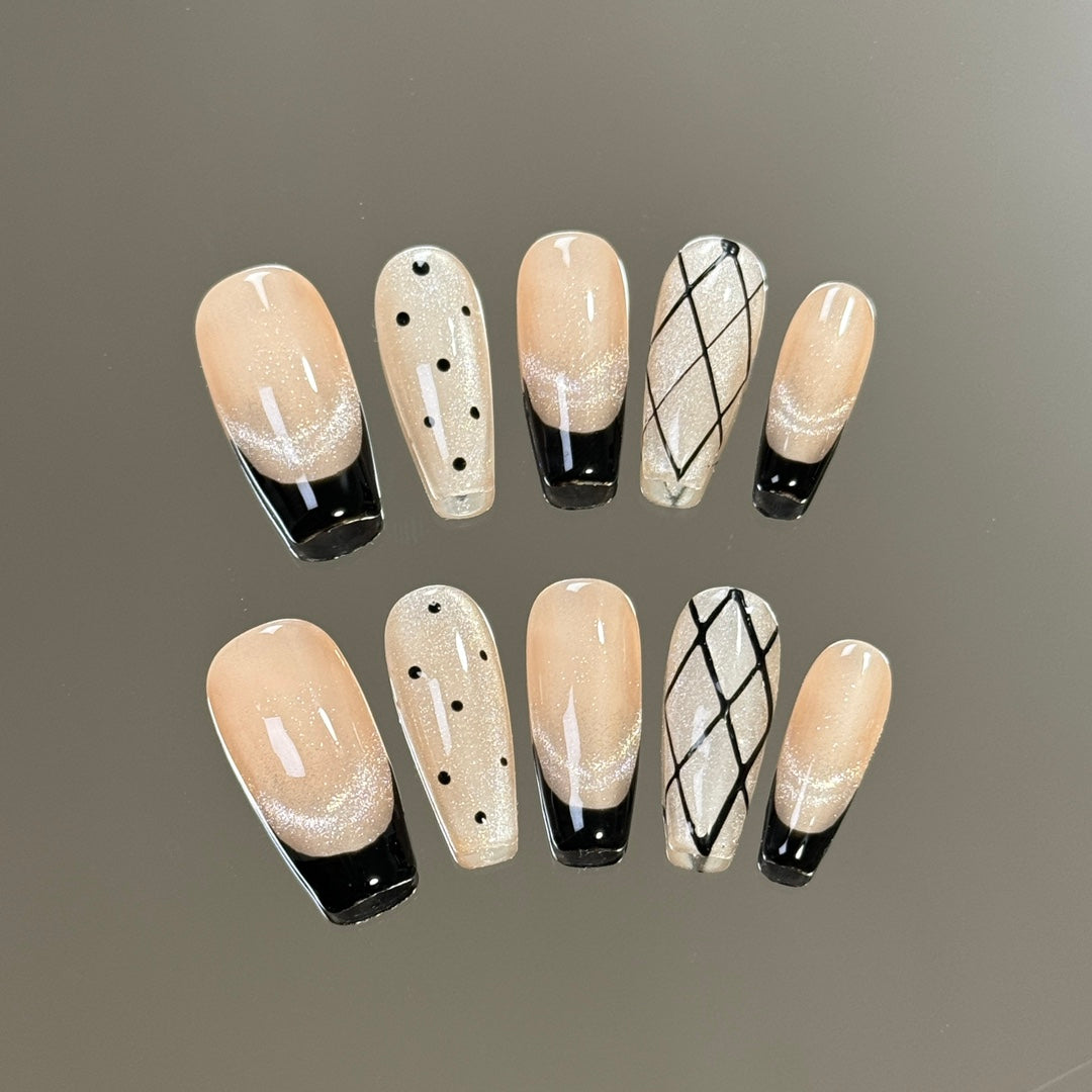 2. Bold French tip presson nails featuring black base and sparkling polka dot accents.