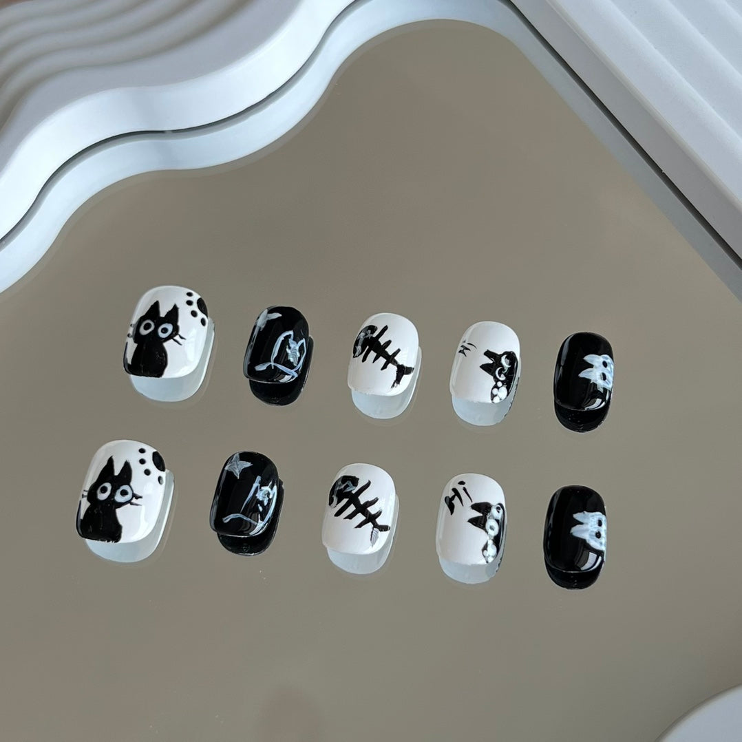 2. Adorable black cat eye design on white presson nails, ideal for short and round nail shapes, showcasing a playful vibe.