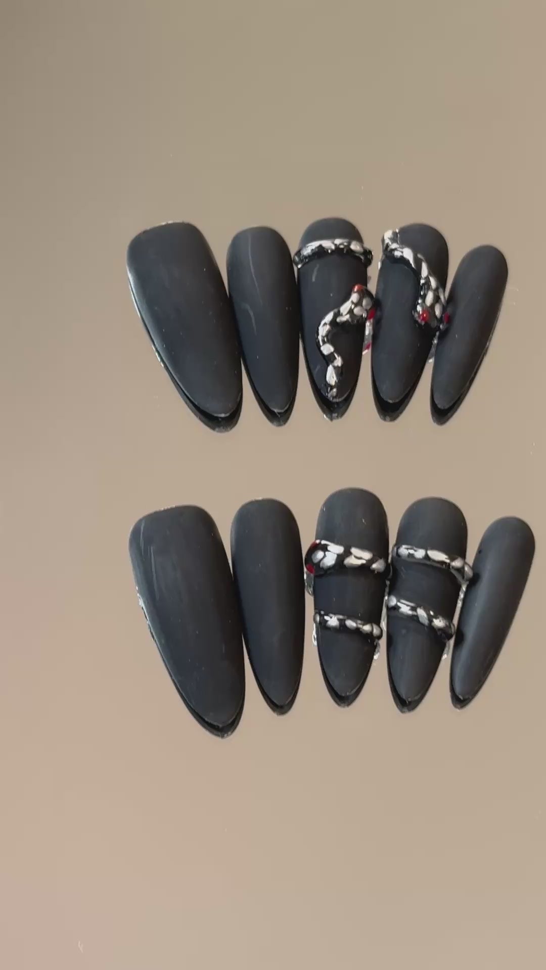 3. Elegant black chrome presson nails featuring an almond shape and a frosted snake design.