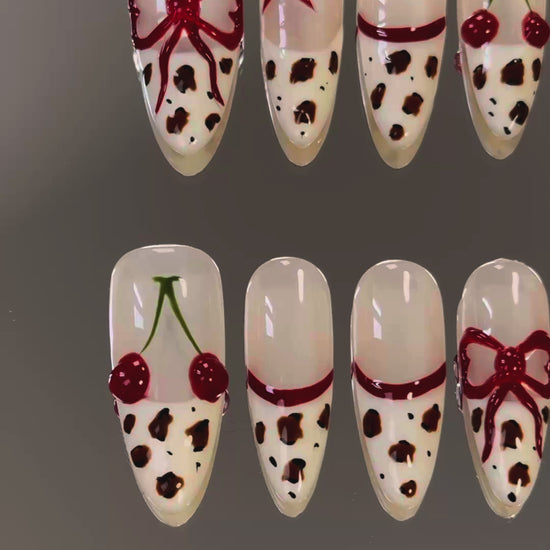 3. "Elegant almondshaped presson nails with a glossy leopard print and cherry red tips for a sophisticated touch."