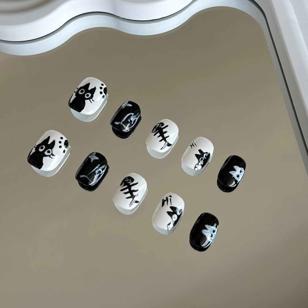 1. Stylish black and white cartoon cat eye presson nails for short round nails, perfect for a chic nail art look.