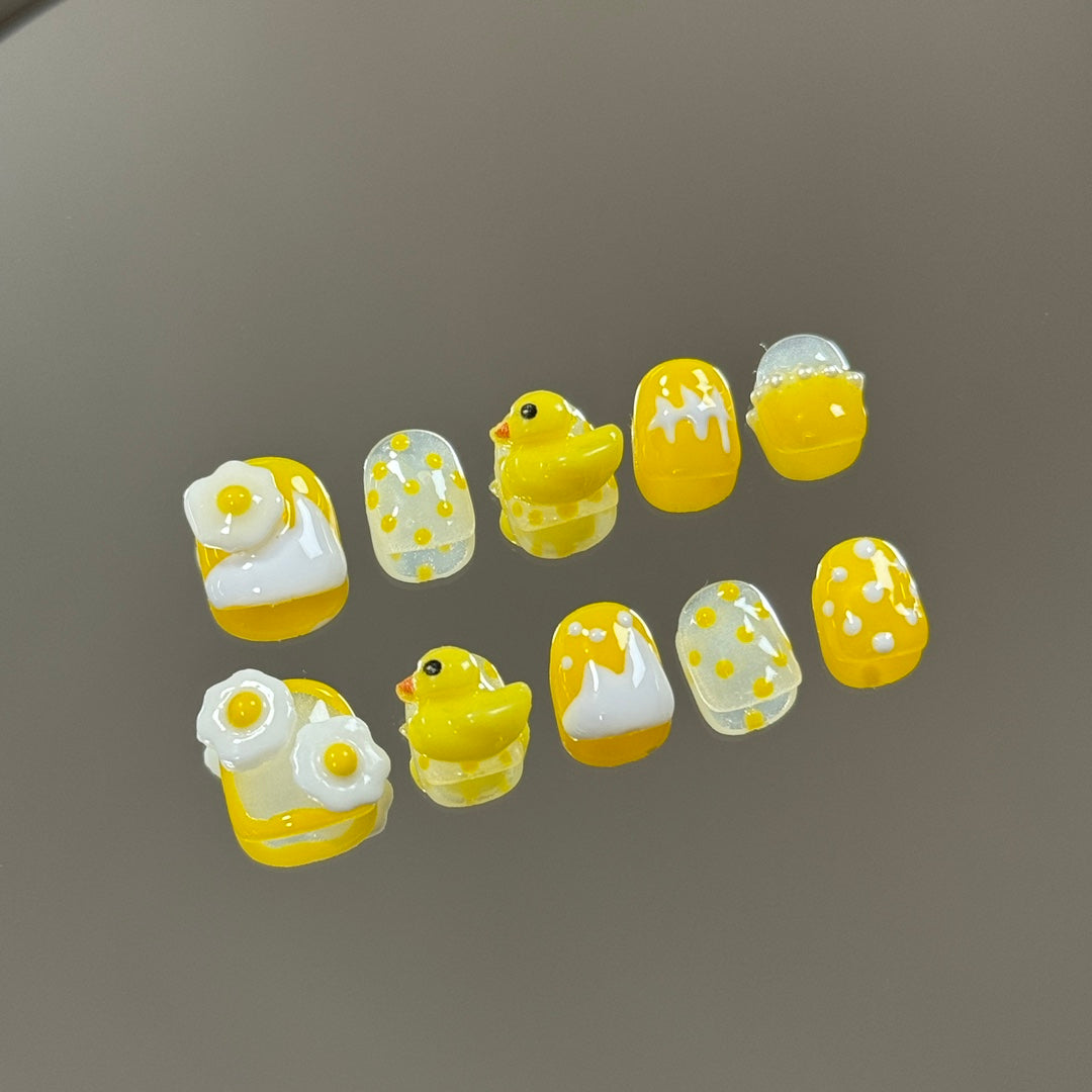 2. Adhesivebacked, easytoapply yellow duck pattern presson nails, ideal for children's nail art.